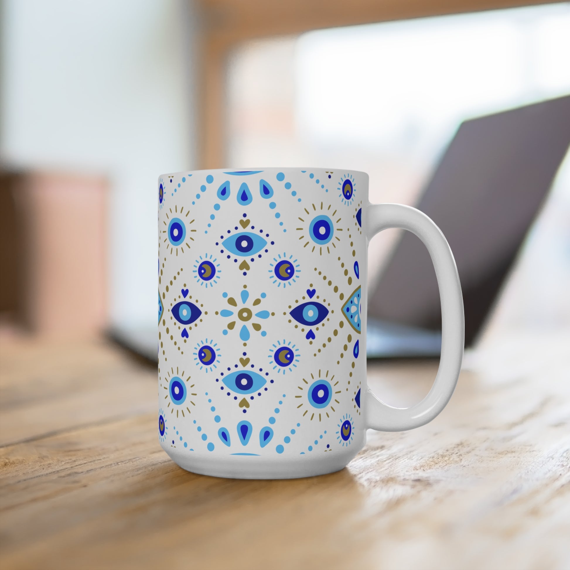 White mug with blue and gold decorative patterns on a wooden surface.